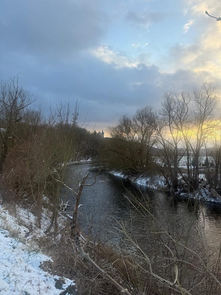 Die Saale im Winterlicht, am Horizont klein der Turm der Weißenburg