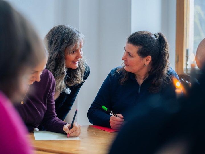 Zwei Teilnehmerinnen im Gespräch über ihren Unterlagen